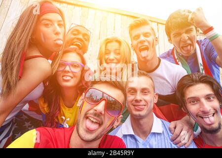 Multinationale Fußballfans, die selfie draußen nehmen - Glückliche multirassische Menschen, die lustige Gesichter für olympische Spiele auf der Kamera machen - Sport gegen rac Stockfoto