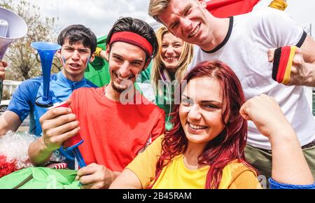 Fröhliche Sportanhänger haben Spaß beim Fußball-Weltspiel - Junge Fans vor dem Fußballspiel außerhalb des Stadions - Freundschaft, Jugend und Feiern Stockfoto