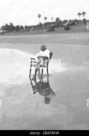 Mahatma Gandhi sitzt auf dem Stuhl am Juhu Beach, Bombay, Mumbai, Maharashtra, Indien, Asien, Mai 1944, altes Bild des Jahrgangs 1900s Stockfoto