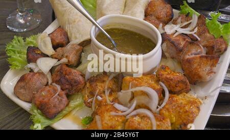 Set aus Shish Kebabs oder Barbecue Shashlik mit Tkemali-Sauce Stockfoto