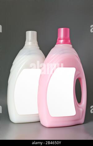 Transparente Waschmittel-Kunststoffflasche mit pink-weißer Flüssigkeit, die auf grau isoliert ist. Stockfoto