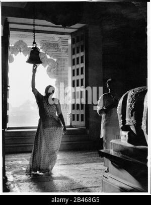 Indische Frau klingende Tempelglocke, Somnath Tempel, Shree Somnath Jyotirlinga Tempel, Prabhas Patan, Veraval, Saurashtra, Gujarat, Indien, Asien, 1963, alter Jahrgang 1900s Bild Stockfoto