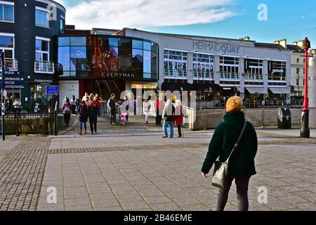 Blick auf die Straße in Richtung Mermaid Quay in Cardiff Bay, mit einer Mischung aus Restaurants, Kino und Geschäften. Stockfoto