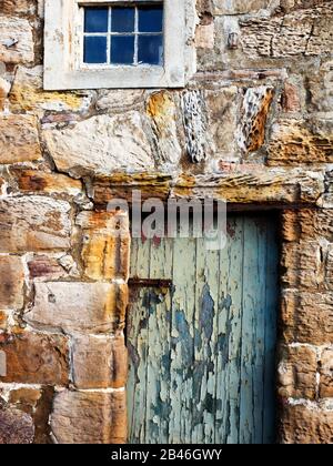 Verwitterte Tür in einem alten Gebäude am Hafen in Crail East Neuk von Fife Scotland Stockfoto