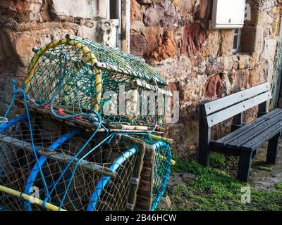 Drei Hummertöpfe gestapelt von einer Bank am Hafen in Crail East Neuk von Fife Scotland Stockfoto