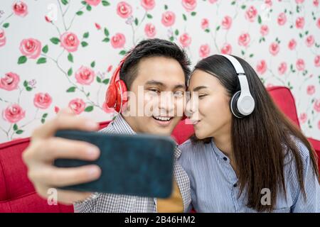 Asiatischer Vlogger von Ehepaaren, der per Handy per Social Media-Kanal, süßes Herz und Küssen, Liebhaber und live auf die Teilnehmer streamen kann Stockfoto