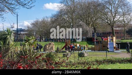 Kinder, die die Spielbereiche im Salt Hill Park, Slough, genießen, während ihre Eltern darauf schauen. Sonniger Tag, Spätwinter. Stockfoto