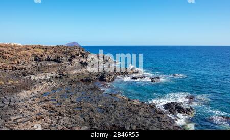 Rau und felsigen Landschaft der Küsten Wanderweg von Montana Amarilla in Amarilla Golf und Golf Del Sur mit Blick auf den kleinen Fischerdörfern Stockfoto