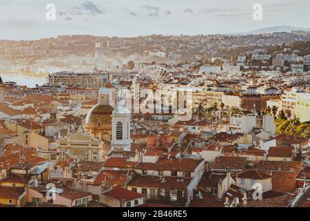 Panoramaaussicht auf das Stadtbild von Nizza, Frankreich: Rote Dächer, großes Riesenrad, Hafen, Häuser, Kirche und Architektur in Nizza. Cote d'Azur fr Stockfoto