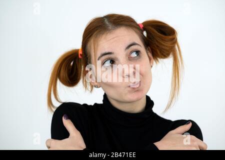 Closeup Portrait eines lustigen rothaarigen Mädchen im Teenageralter mit kindischen Frisur isoliert auf weißem Hintergrund. Stockfoto