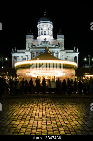 Weihnachtskarusselldekoration senatsplatz in helsinki mit Kirche im Hintergrund Stockfoto