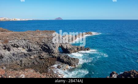 Rau und felsigen Landschaft der Küsten Wanderweg von Montana Amarilla in Amarilla Golf und Golf Del Sur mit Blick auf den kleinen Fischerdörfern Stockfoto