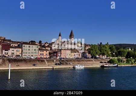 Frankreich, Blick auf die Stadt Tournus am Fluss Saone, das Departement Bourgogne-Franche-Comté, das antike römische Castrum, sehen wir die markanten Glockentürme der berühmten katholischen Kirche St. Philibert (im burgundischen Romanik). Auf dem Fluss Saône gibt es ein Boot. Stockfoto