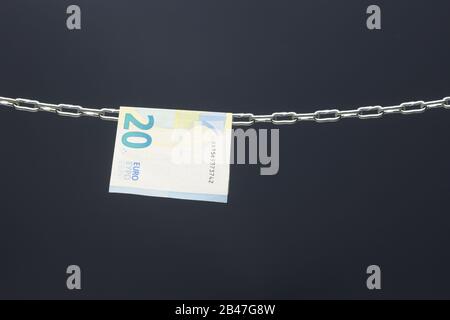 Geld, das in einer Kette gehalten wird oder an einer Kette hing; gesetzliches Zahlungsmittel in Papierform; Euro, Währung der europäischen Wirtschaftsgemeinschaft, Gemeinsamer Markt. Stockfoto