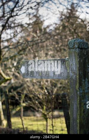 Auf Bodmin Moor ein Holzschild, das dem Groben Tor die Richtung gibt, und das Denkmal für die 43. Wessex-Division, die im Zweiten Weltkrieg ihr Leben verloren hat. Stockfoto