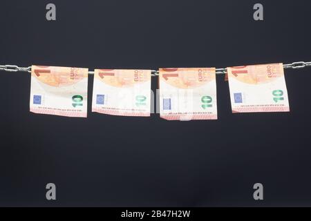 Geld, das in einer Kette gehalten wird oder an einer Kette hing; gesetzliches Zahlungsmittel in Papierform; Euro, Währung der europäischen Wirtschaftsgemeinschaft, Gemeinsamer Markt. Stockfoto