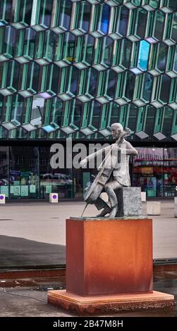 Europa, Island, Reykjavik, Blick auf die Bronzestatue des dänischen Cellisten Erling Blöndal Bengtsson vom Bildhauer Ólöf Pálsdóttir vor der Konzerthalle Harpa, Architekt: Henning Larsen Architekten und Ólafur Stockfoto