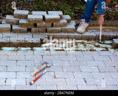 Wartungsarbeiten an ebnet mit Verriegelung Pflastersteine. Baustoffindustrie; konkrete Produkte für Straße oder Gehweg Bau. Stockfoto