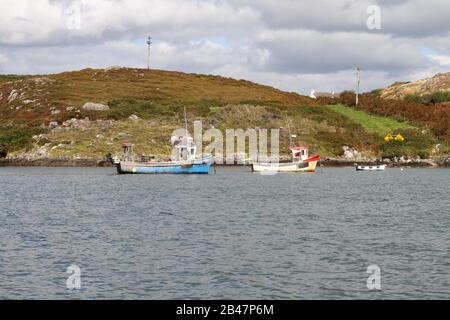 Herbst in der Roaringwater Bay mit drei kleinen Fischerbooten in absteigender Größe vor der Küste von Heir Island im County Cork. Stockfoto