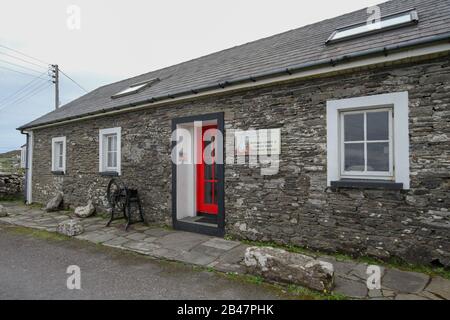 Außerhalb eines alten irischen Schulhauses befindet sich heute das Kulturzentrum, Museum und Ausstellungszentrum auf Cape Clear Island, einer Gaeltacht-Insel, Irland, Stockfoto