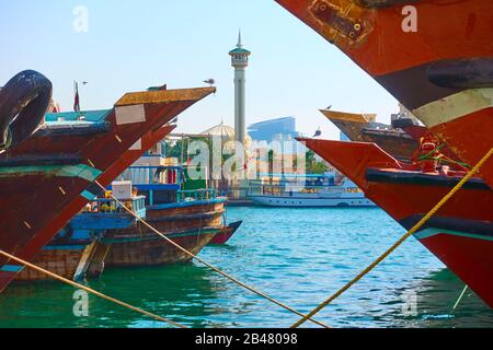 Leiter arabischer Schiffe dhow in Deira und Minarett der Garand-Moschee auf der anderen Seite des Creek in Dubai, Vereinigte Arabische Emirate (VAE) Stockfoto