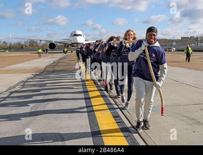 (Von vorne nach hinten) Nicola Adams, Gabby Logan, Gary Lineker, Joe Wicks, Iwan Thomas und Alfie Hewett schließen sich den Mitarbeitern an, um den Guinness-Weltrekord für den schwersten 100-m-A350-Flugzeugzug während einer Sporthilfe am Flughafen Heathrow in London zu brechen. Stockfoto