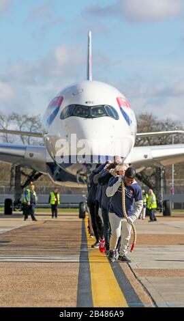 (Von vorne nach hinten) Nicola Adams, Gabby Logan, Gary Lineker, Joe Wicks, Iwan Thomas und Alfie Hewett schließen sich den Mitarbeitern an, um den Guinness-Weltrekord für den schwersten 100-m-A350-Flugzeugzug während einer Sporthilfe am Flughafen Heathrow in London zu brechen. Stockfoto