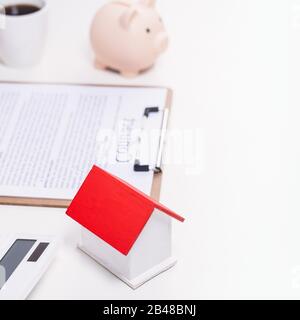 Geschäftskonzept - Der Junge Asiat in blauem Hemd berechnet, unterzeichnet den Vertrag über den Kauf einer Hauskreditzahlung, die Zahlung von Versicherungen, Steuern, Nahaufnahme. Stockfoto