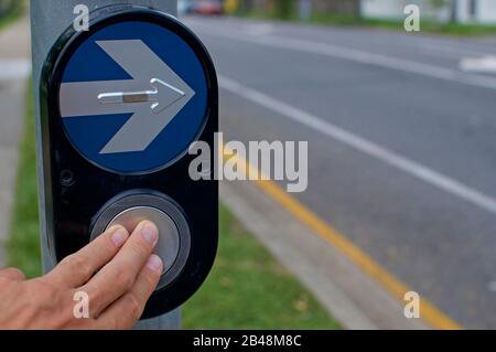 Finger drücken auf eine Ampeltaste in Brisbane. Dies kann als Entscheidungskonzept und als Voranschreiten verwendet werden Stockfoto