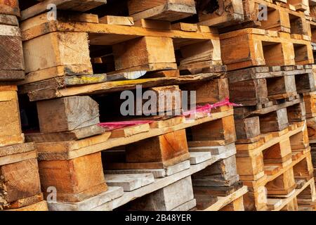 Viele Stapel gebrauchte Holzpaletten vom Euro-Typ im Lager sind bereit für das Recycling. Industrieller Hintergrund. Nahaufnahme. Im Freien. Stockfoto