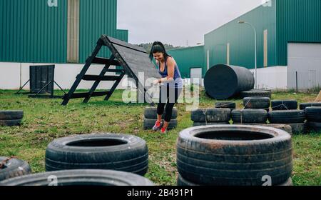 Teilnehmer in einen Hindernisparcours Räder ziehen Stockfoto