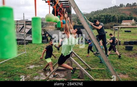 Teilnehmer Hindernisparcours suspension tun Stockfoto