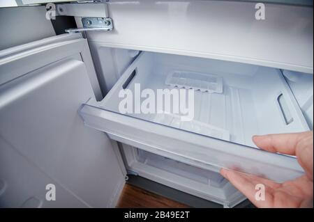 Öffnen Sie einen sauberen Kühl-Gefrierbehälter mit Eiswürfeln Stockfoto