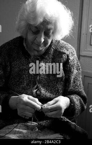 Alte Frau zu Hause stricken. Schwarz und weiß. Stockfoto