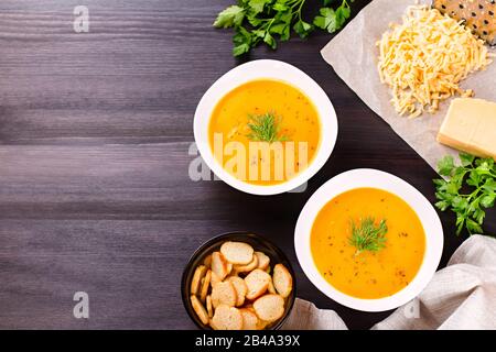 Kürbiscremensuppe mit Croutons und frischem Dill und Petersilie auf dunklem Holzhintergrund Stockfoto