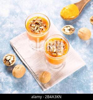 Gesunder Kürbis-Smoothie mit Walnüssen in Gläsern auf rustikalem Hintergrund Stockfoto