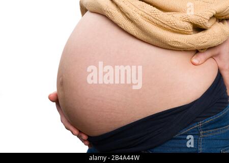 Acht Monate Schwangerschaftskonzept mit der Hand der Frau, die großen Bauch und den unteren Rücken des Schnittholzes hält Stockfoto