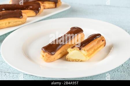 Eclairs mit Schokoladenauffüllen auf Servierplatte Stockfoto