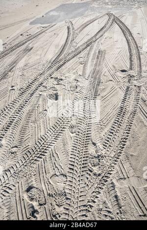 Reifenspuren und Fußabdrücke im Sand Stockfoto