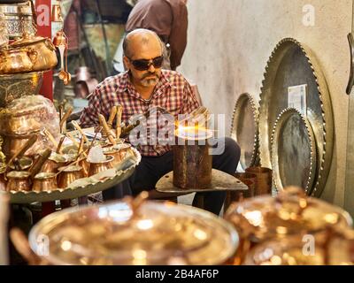 April 2017 von einem Kupferschmied im großen Basar der Stadt Isfahan im Süden des Iran eingenommen. Der Basar (Bazar-e Qeysariyeh oder Bazar-e Bozorg) am Imam-Platz (Meidan-e Emam) gilt als einer der größten und aktivsten Basare im Iran und ist für die Vielfalt und Qualität seiner Handwerke bekannt. Weltweite Verwendung Stockfoto