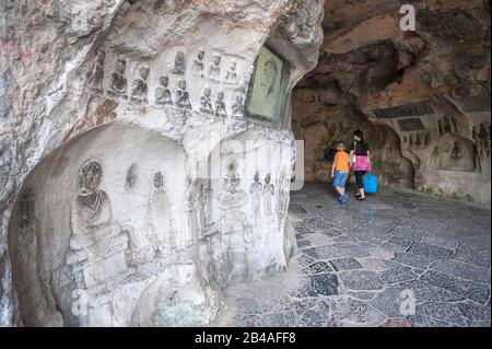 Alte buddhistische Schnitzereien in der Windhöhle am Fuß des Gefalteten Brocade Hill (Diecai Shan) in Guilin, Provinz Guangxi Stockfoto