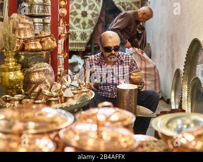 April 2017 von einem Kupferschmied im großen Basar der Stadt Isfahan im Süden des Iran eingenommen. Der Basar (Bazar-e Qeysariyeh oder Bazar-e Bozorg) am Imam-Platz (Meidan-e Emam) gilt als einer der größten und aktivsten Basare im Iran und ist für die Vielfalt und Qualität seiner Handwerke bekannt. Weltweite Verwendung Stockfoto