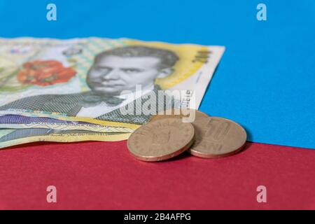 Rumänischen Banknoten und Münzen auf blauem und rotem Hintergrund. Kolosseup von RON, rumänischer Währung. Rumänischer RON, Lei-Banknoten, herausgegeben von BNR, Nationalverbot Stockfoto