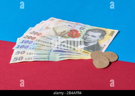 Rumänischen Banknoten und Münzen auf blauem und rotem Hintergrund. Kolosseup von RON, rumänischer Währung. Rumänischer RON, Lei-Banknoten, herausgegeben von BNR, Nationalverbot Stockfoto