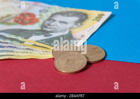 Rumänischen Banknoten und Münzen auf blauem und rotem Hintergrund. Kolosseup von RON, rumänischer Währung. Rumänischer RON, Lei-Banknoten, herausgegeben von BNR, Nationalverbot Stockfoto