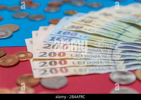 Rumänischen Banknoten und Münzen auf blauem und rotem Hintergrund. Kolosseup von RON, rumänischer Währung. Rumänischer RON, Lei-Banknoten, herausgegeben von BNR, Nationalverbot Stockfoto