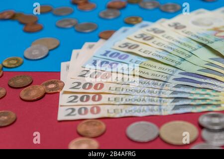 Rumänischen Banknoten und Münzen auf blauem und rotem Hintergrund. Kolosseup von RON, rumänischer Währung. Rumänischer RON, Lei-Banknoten, herausgegeben von BNR, Nationalverbot Stockfoto