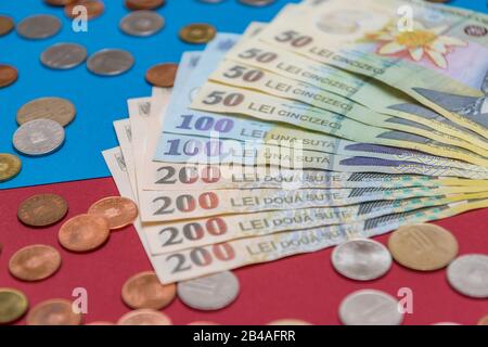 Rumänischen Banknoten und Münzen auf blauem und rotem Hintergrund. Kolosseup von RON, rumänischer Währung. Rumänischer RON, Lei-Banknoten, herausgegeben von BNR, Nationalverbot Stockfoto