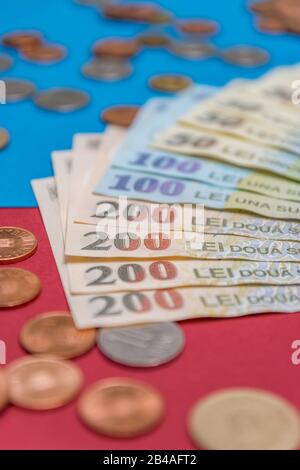 Rumänischen Banknoten und Münzen auf blauem und rotem Hintergrund. Kolosseup von RON, rumänischer Währung. Rumänischer RON, Lei-Banknoten, herausgegeben von BNR, Nationalverbot Stockfoto