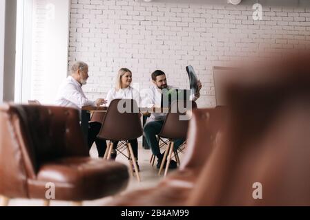 Das medizinische Team von drei erwachsenen und jungen Ärzten diskutiert Röntgenaufnahmen der Brust Stockfoto